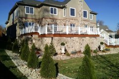Landesign-Hardscape-Masonry-Valley-Forge-Entire-house-with-stone-patiofire-place-boarder-wall-under-the-deck-with-columns